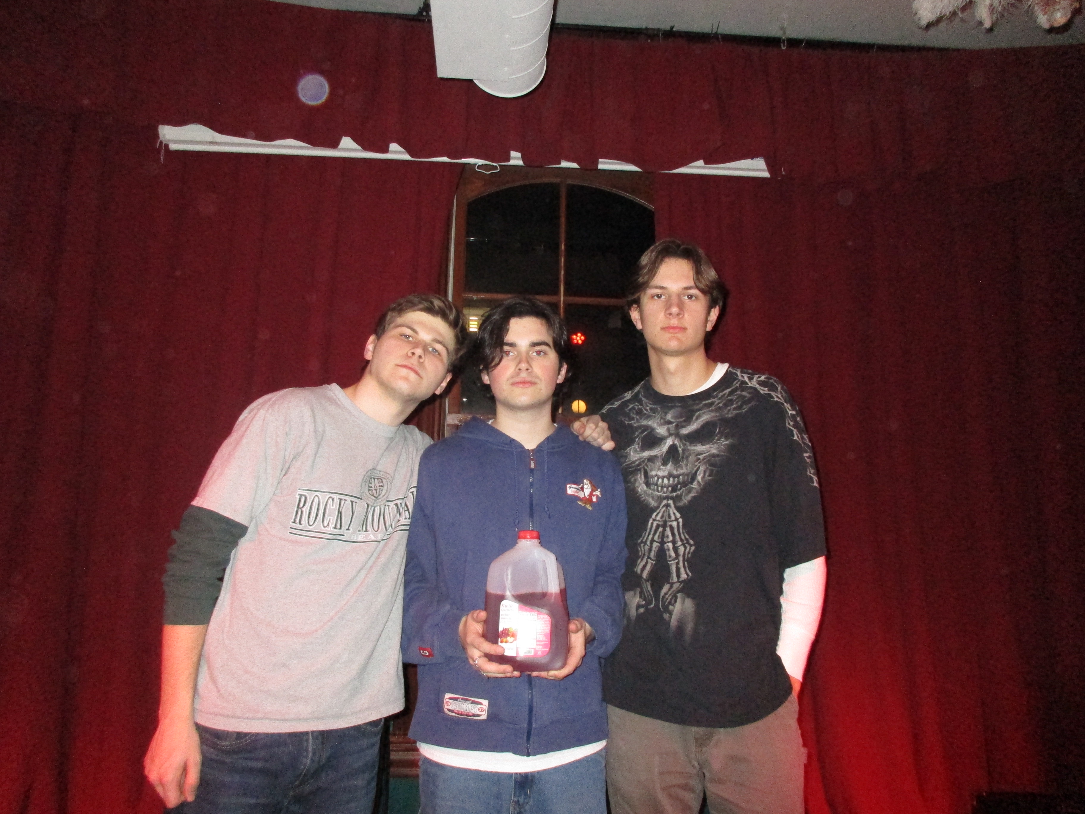 The members of Gallon of Red holding a red gallon.